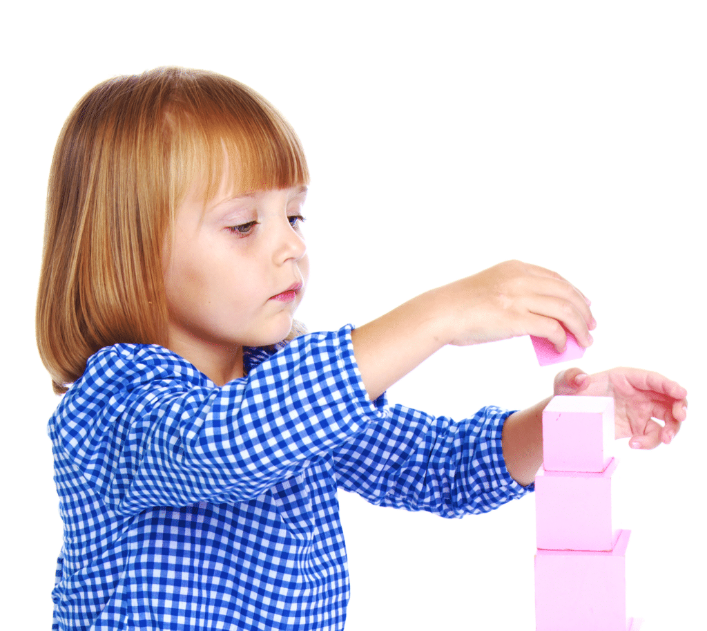 A young child stacking pink blocks on top of each other.