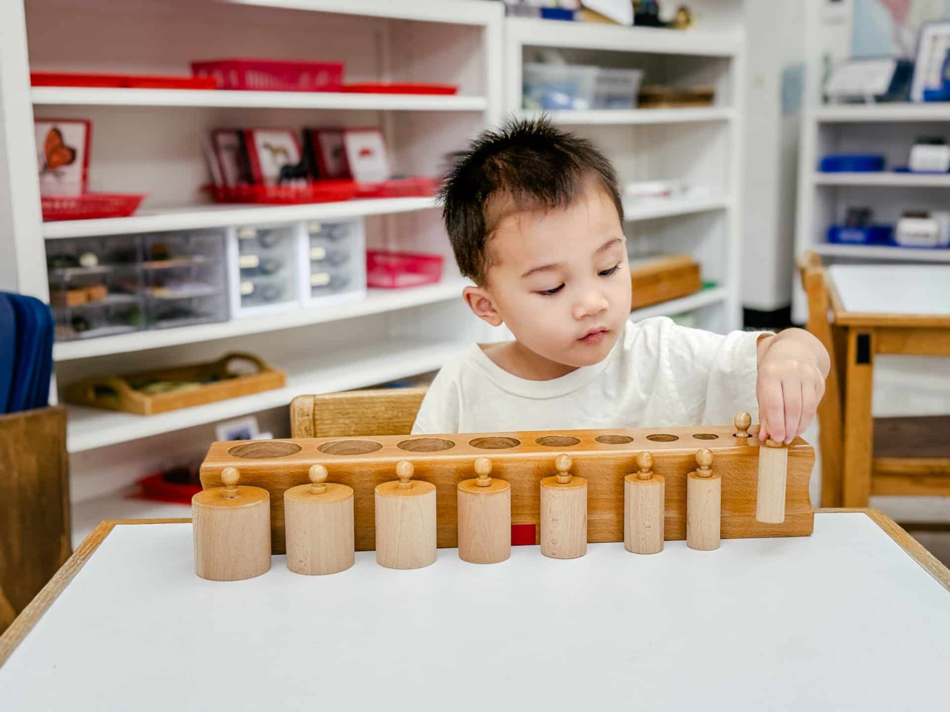 Primary child working with knob cylinders.