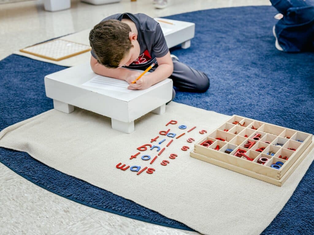 Primary child building words with movable alphabet.